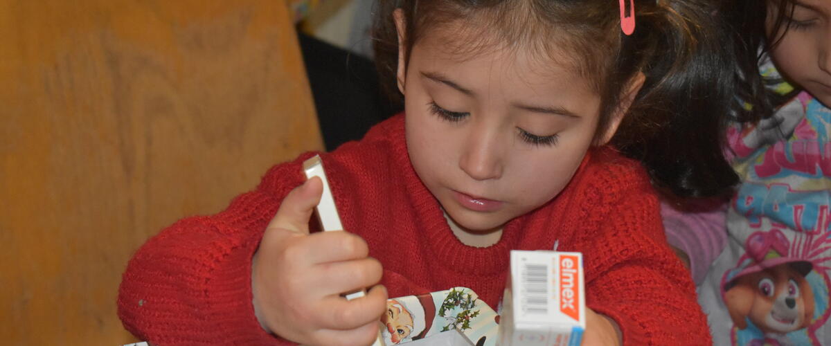 Kind packt Geschenk mit Herz aus