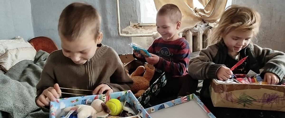 Kinder packen Geschenke mit Herz aus